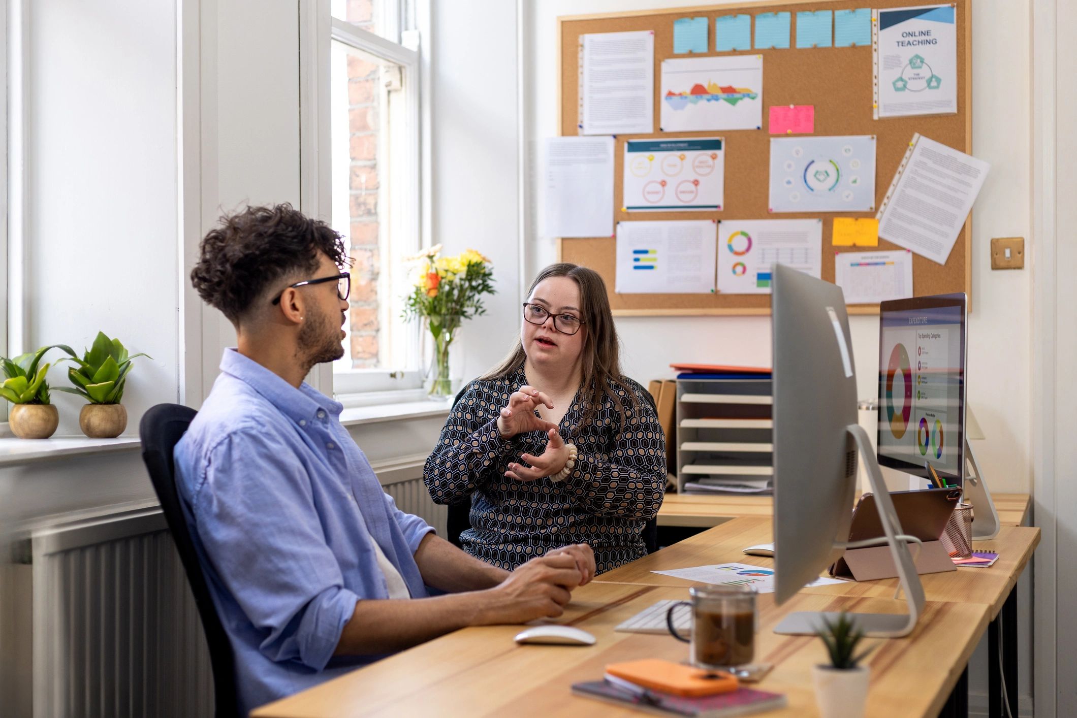 Two colleagues talking in a bright office