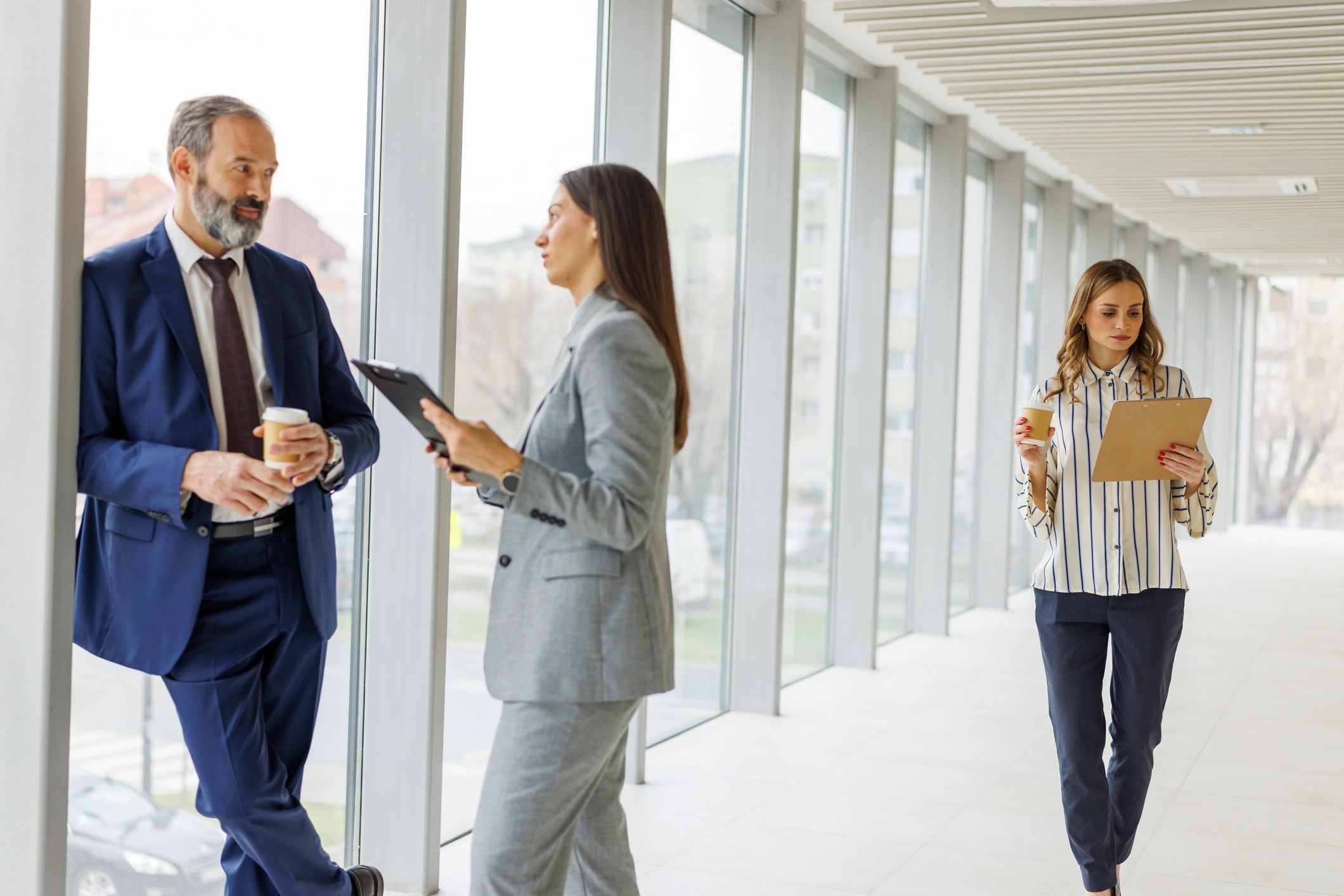 Business professionals collaborating in a modern office hallway